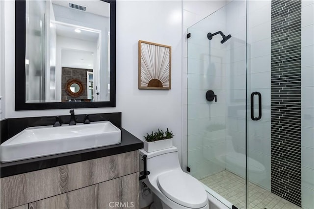 full bathroom with a shower stall, toilet, and vanity
