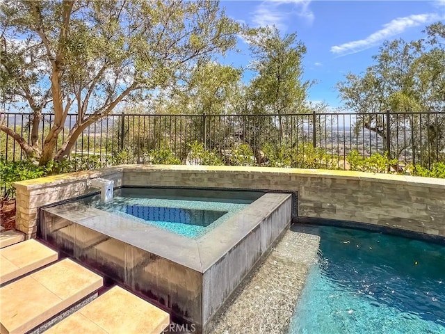 view of swimming pool with an in-ground hot tub and fence