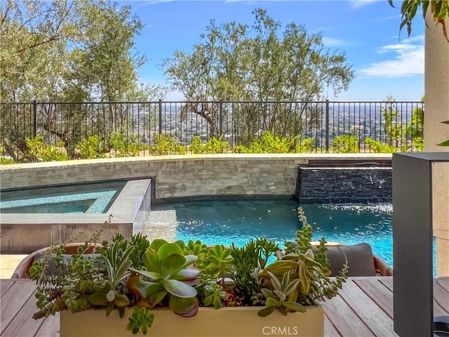 view of pool featuring an in-ground hot tub and fence