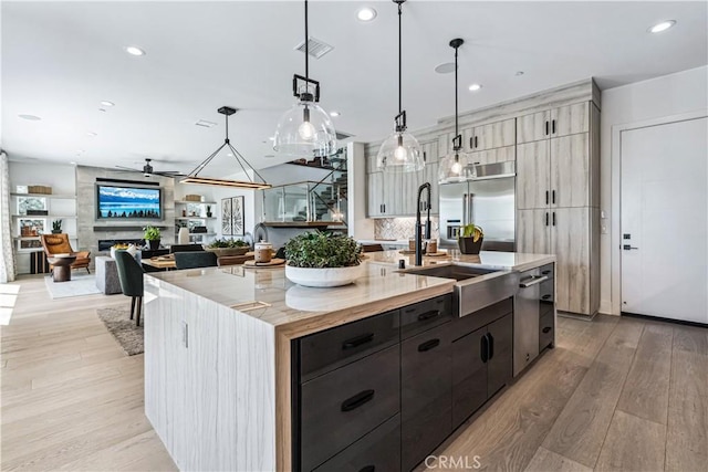 kitchen with stainless steel appliances, light wood finished floors, a large island, decorative light fixtures, and recessed lighting