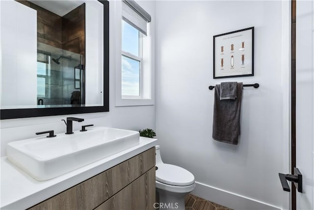 bathroom featuring a shower stall, toilet, and vanity