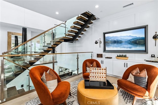 living area featuring wood finished floors, recessed lighting, and stairs