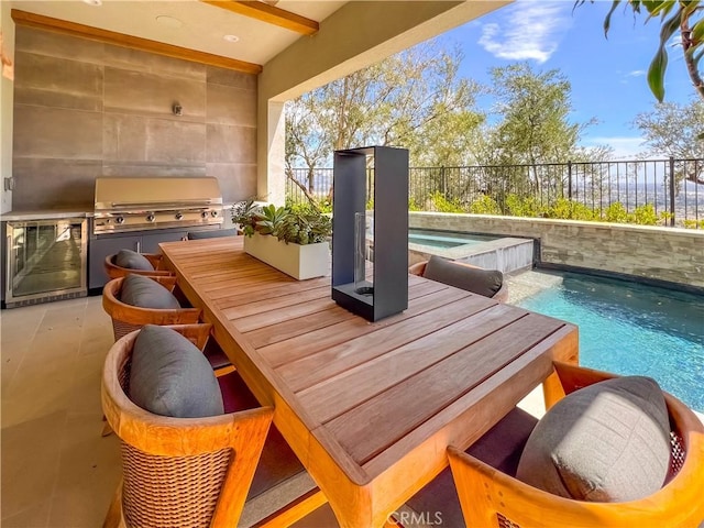 balcony featuring exterior kitchen, view of pool, grilling area, beverage cooler, and outdoor dining space