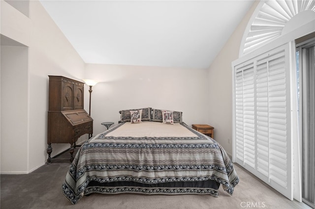 carpeted bedroom with lofted ceiling and baseboards