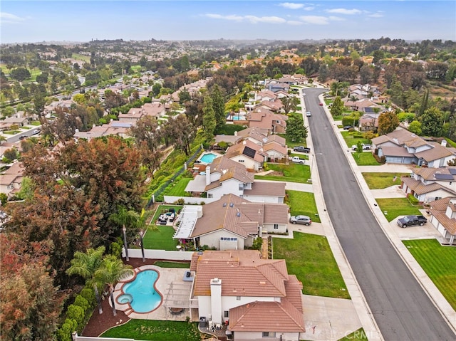 aerial view of property and surrounding area featuring nearby suburban area and a pool