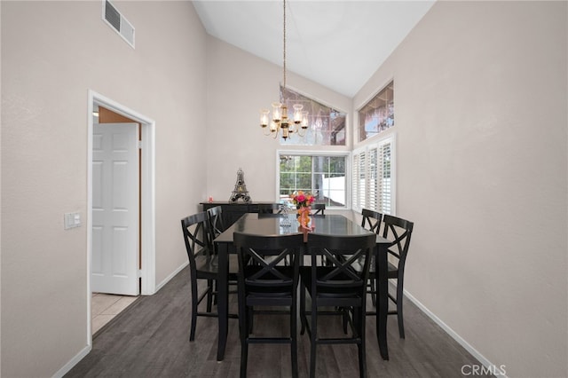 dining area with high vaulted ceiling, a chandelier, baseboards, and wood finished floors