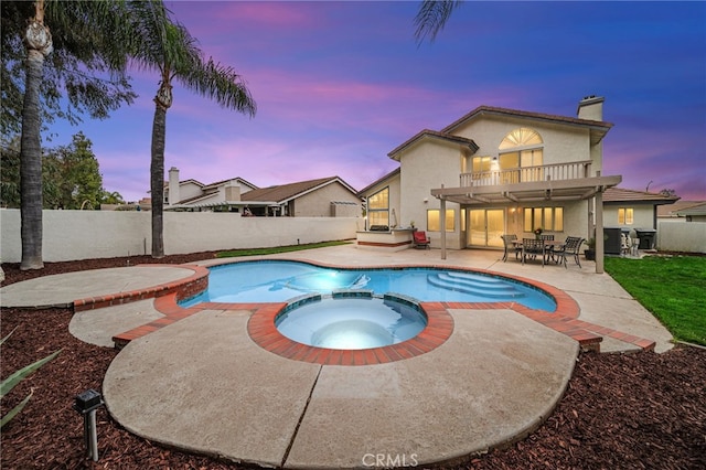 view of swimming pool with a fenced backyard, a pool with connected hot tub, a patio area, outdoor dining area, and grilling area