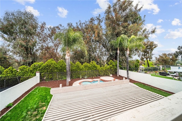 surrounding community featuring a hot tub, a fenced backyard, and view of scattered trees