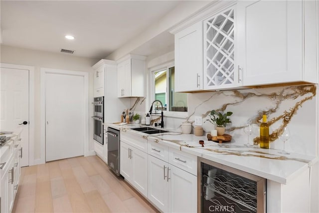 1741 Perch St, San Pedro, CA 90732 - kitchen with appliances with stainless steel finishes, wine cooler, a sink, white cabinetry, and recessed lighting