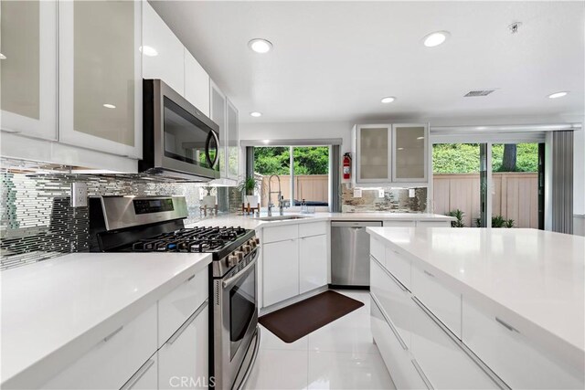 1225 Via Presa, San Clemente, CA 92672 - kitchen featuring stainless steel appliances, a sink, decorative backsplash, light countertops, and white cabinetry