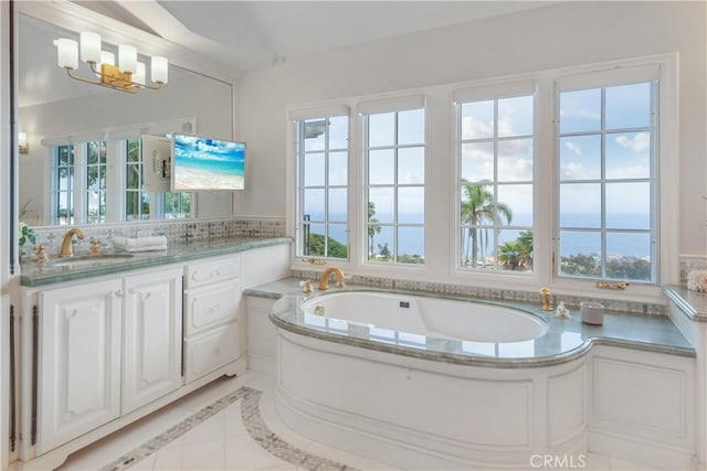 bathroom featuring inlaid floor details, a bath, vanity, and a chandelier