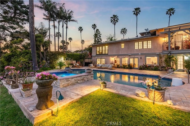 outdoor pool with french doors, an in-ground hot tub, outdoor lounge area, and a patio