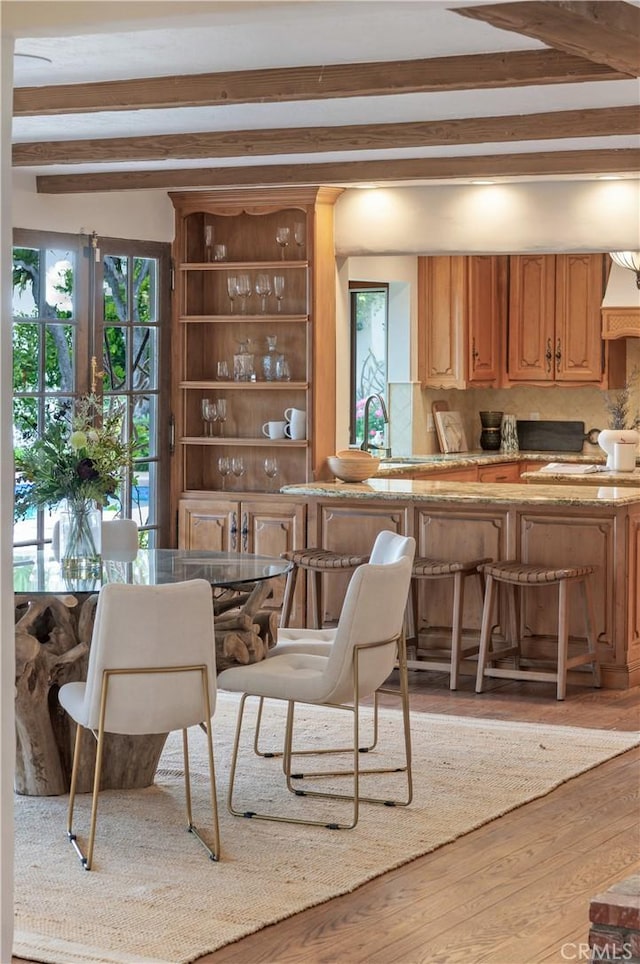 kitchen featuring beam ceiling, wood finished floors, and decorative backsplash