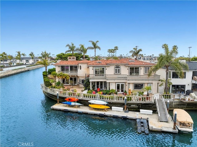 842 Harbor Island Dr, Newport Beach, CA 92660 - back of property with a water view, a tile roof, stucco siding, and a balcony