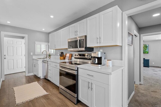 3883 Mount Everest Blvd, San Diego, CA 92111 - kitchen with appliances with stainless steel finishes, light countertops, white cabinetry, baseboards, and a sink