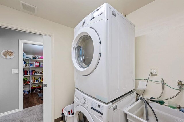 3883 Mount Everest Blvd, San Diego, CA 92111 - laundry room with stacked washer / dryer, carpet flooring, and baseboards