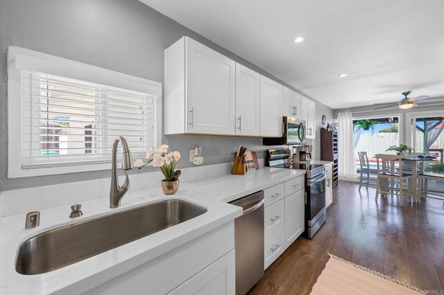 3883 Mount Everest Blvd, San Diego, CA 92111 - kitchen with stainless steel appliances, a sink, ceiling fan, white cabinetry, and dark wood-style flooring