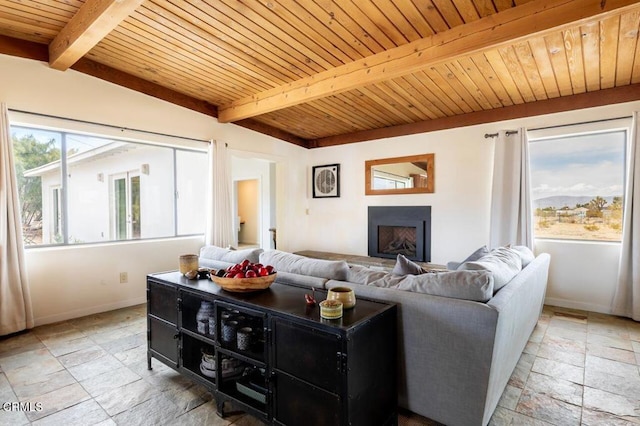 living room with stone tile flooring, wood ceiling, baseboards, beamed ceiling, and a fireplace