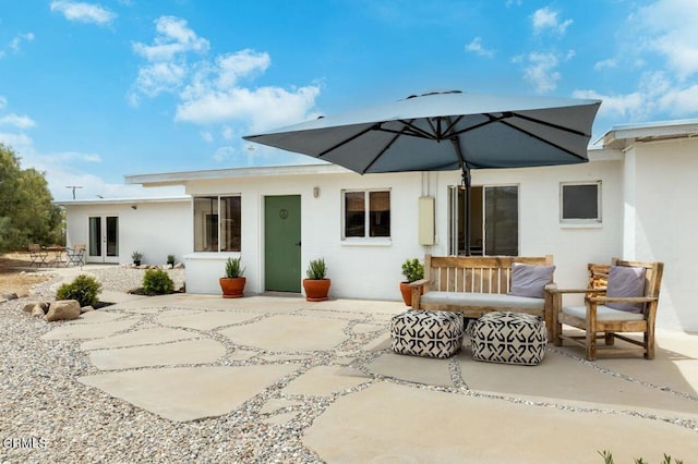 back of property with a patio, french doors, and concrete block siding