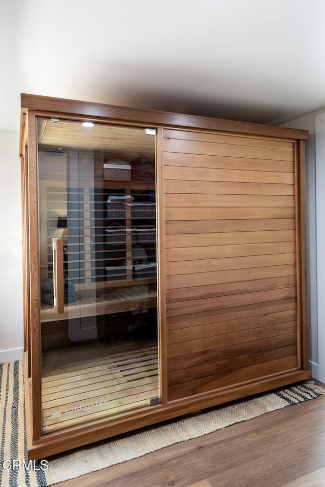 relaxing sauna / steam room with wood finished floors and baseboards