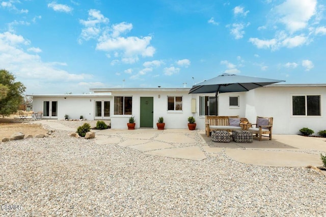 back of house featuring a patio area, stucco siding, an outdoor hangout area, and french doors