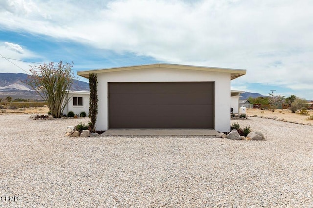garage featuring gravel driveway and a mountain view