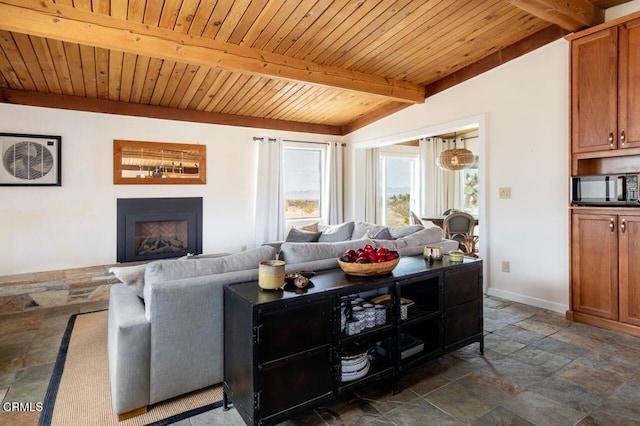 living area featuring stone tile floors, beam ceiling, wood ceiling, baseboards, and a fireplace