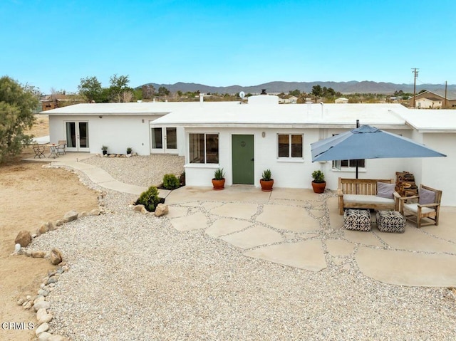 back of house featuring a mountain view, french doors, and a patio