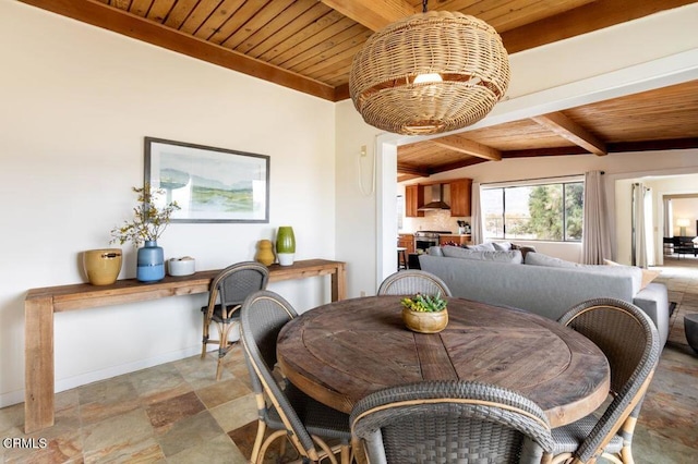 dining room with wood ceiling, stone finish floors, beam ceiling, and baseboards