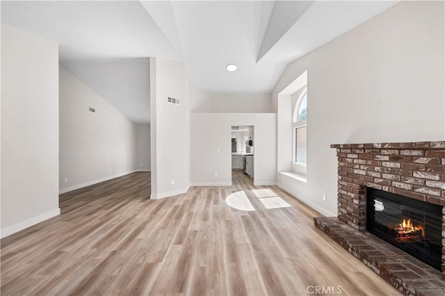 1032 Glenn Ct, Lancaster, CA 93535 - unfurnished living room with lofted ceiling, a fireplace, light wood finished floors, and baseboards