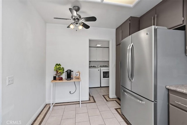 kitchen with freestanding refrigerator, washing machine and clothes dryer, a ceiling fan, light countertops, and light tile patterned floors