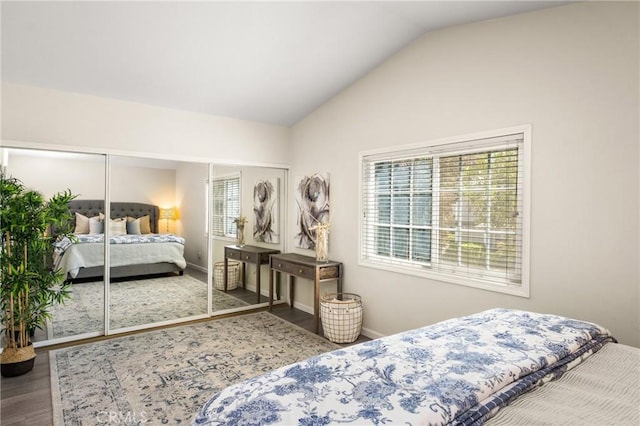 bedroom with wood finished floors, lofted ceiling, and baseboards