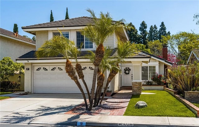 traditional-style home featuring driveway, a garage, stucco siding, and a front yard