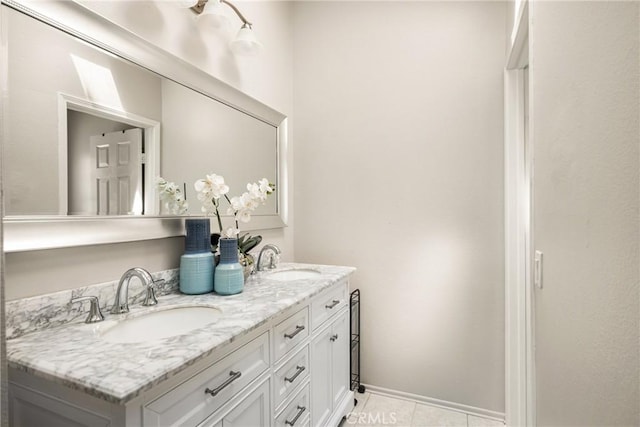 full bath featuring tile patterned floors, double vanity, and baseboards