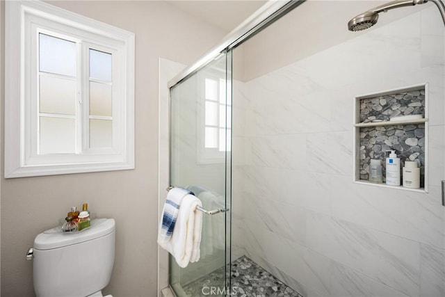 bathroom with a shower stall and toilet