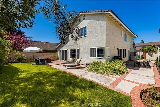 rear view of property with stucco siding and a patio