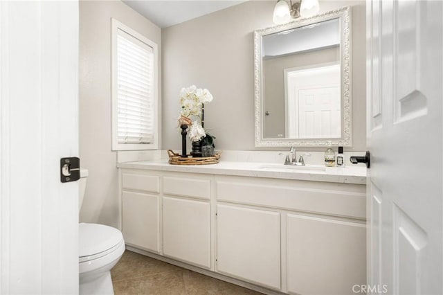 bathroom with toilet, tile patterned floors, and vanity