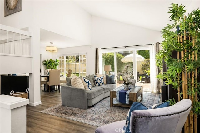 living room featuring wood finished floors, high vaulted ceiling, and baseboards