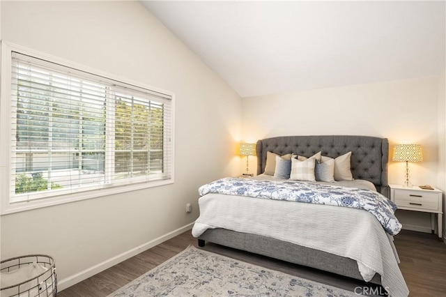 bedroom with vaulted ceiling, wood finished floors, and baseboards
