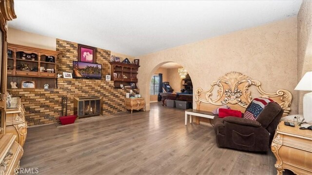 4536 N Irwindale Ave, Covina, CA 91722 - living area with arched walkways, wood finished floors, and a fireplace