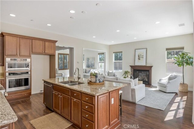 51 Carrington, Irvine, CA 92620 - kitchen featuring appliances with stainless steel finishes, dark wood-style floors, brown cabinetry, open floor plan, and recessed lighting
