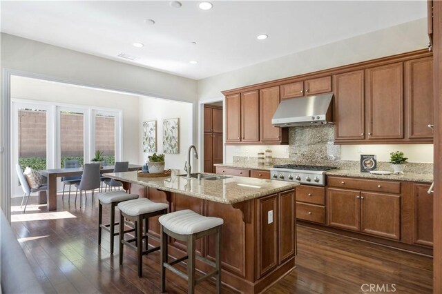 51 Carrington, Irvine, CA 92620 - kitchen featuring under cabinet range hood, gas cooktop, dark wood-type flooring, a kitchen breakfast bar, and recessed lighting