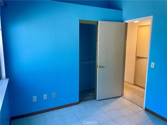 unfurnished bedroom featuring a closet and light tile patterned floors
