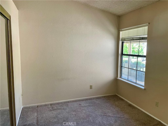 unfurnished room with carpet flooring and baseboards