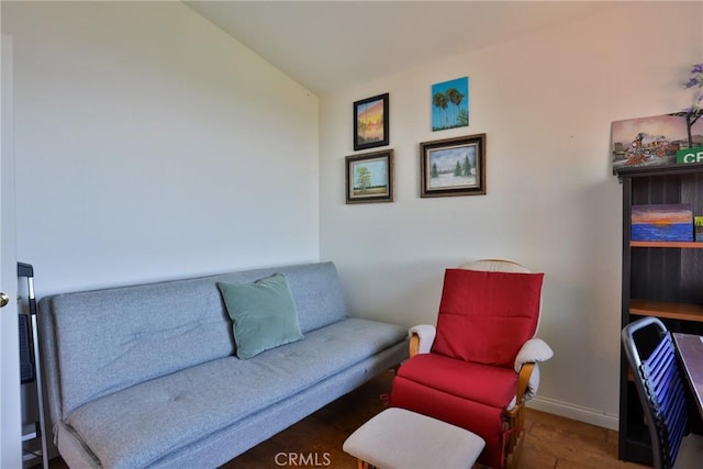 living area with baseboards, wood finished floors, and lofted ceiling