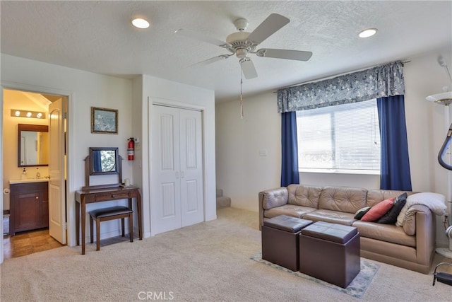 carpeted living area featuring a textured ceiling, a ceiling fan, and recessed lighting