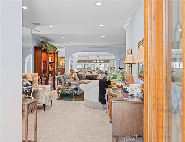living area with ornate columns, crown molding, arched walkways, carpet, and recessed lighting
