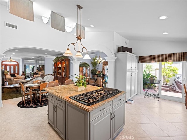 kitchen with arched walkways, ornate columns, black gas cooktop, light tile patterned floors, and recessed lighting