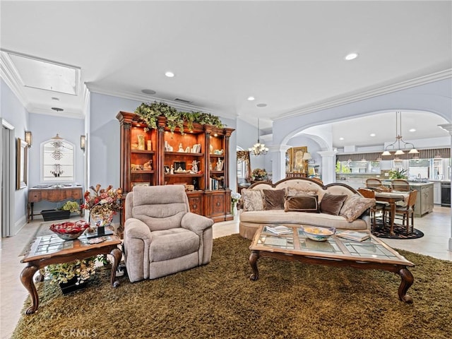 living room featuring arched walkways, decorative columns, crown molding, a chandelier, and recessed lighting
