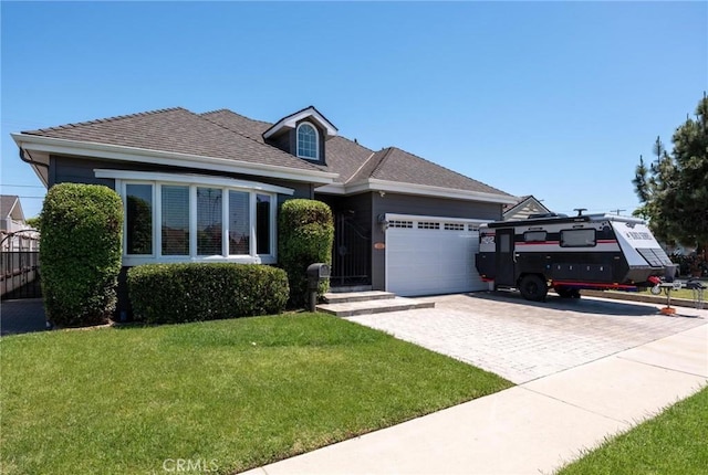 view of front facade with an attached garage, a front yard, and decorative driveway